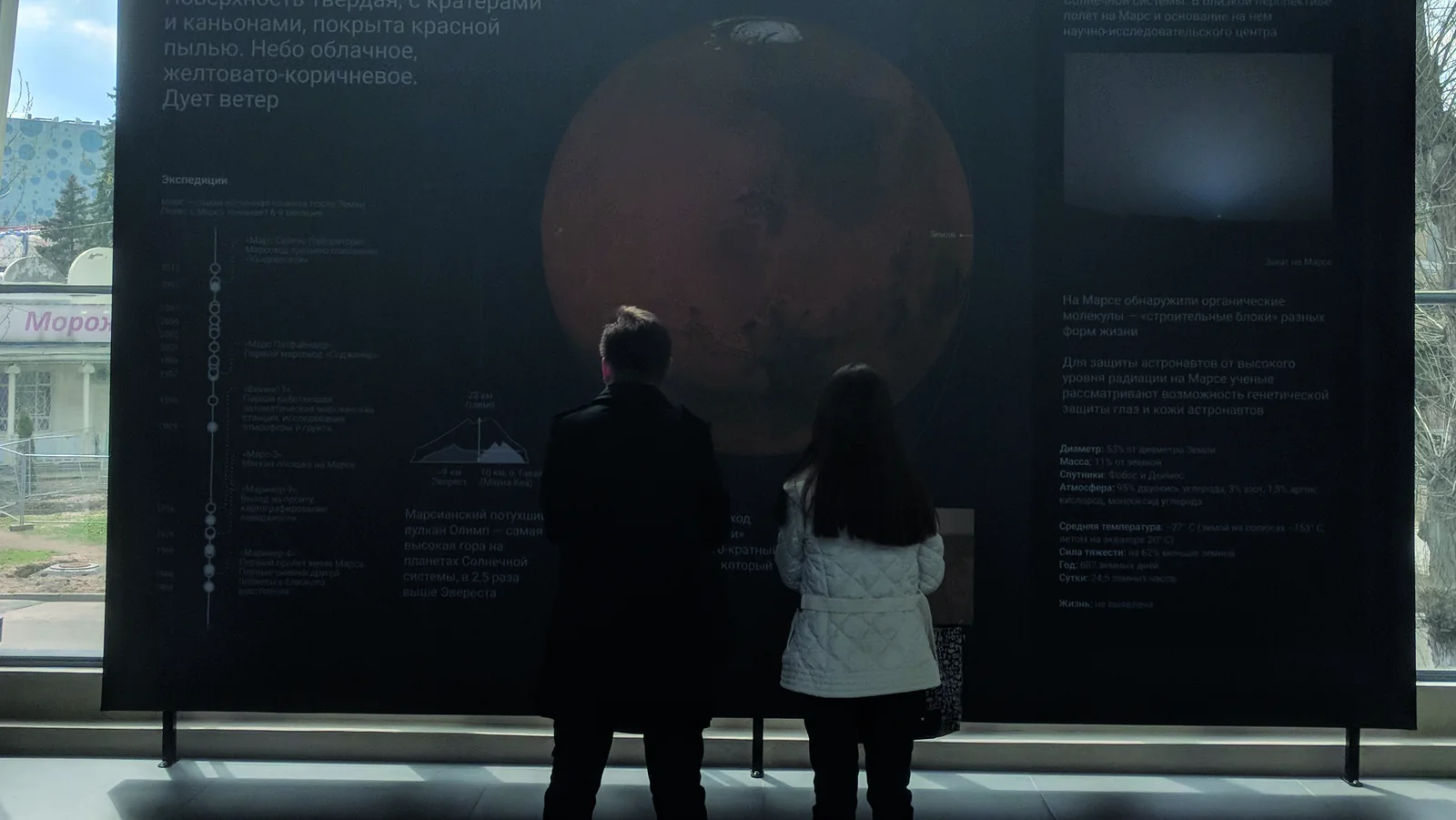 Two visitors reading the Mars plate